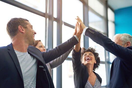 Business people, group high five and happy in office with teamwork, smile and support for company goals. Men, women and hands in air for team building, achievement and celebration at insurance agency