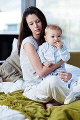 Fototapeta na wymiar Baby, mother and sad with postpartum on bed at family house and problem with stress or being tired. Mom, newborn and depression with mental health at home with insomnia about child development.