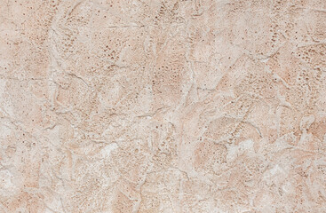 abstract background of an old embossed concrete beige wall close up