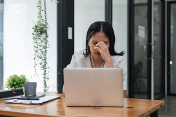 burnout or tired business woman is sleepy in the office from deadlines, overworked or overwhelmed. Depression, fatigue or exhausted female worker working on computer at desk