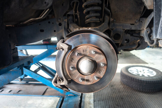 Close up brake discs car without wheel .Old and dirty Disc brake replacement on car - Disk Brake System.