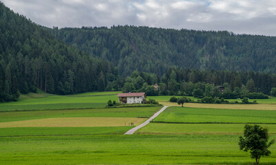 Idyllic spring colorful rural landscape in Switzerland. Farm houses with meadow and rural landscape on a blue sky spring day. Mountains in the background.