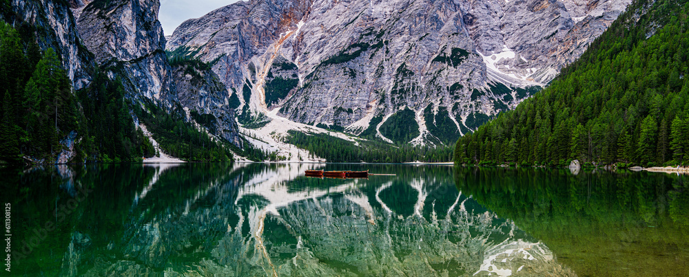 Wall mural Mountain blue lake water landscape. Braies lake with crystal water in background of mountains. Dolomites, Italy.