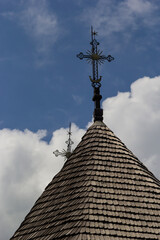 Obraz premium old wooden church against the blue sky in Ukraine, wooden roof with a cross