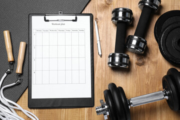 Clipboard with workout plan and sports equipment on wooden table, flat lay. Personal training