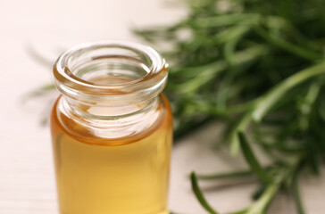 Bottle of rosemary oil on blurred background, closeup. Space for text