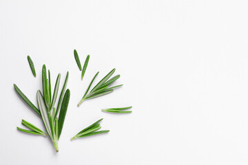 Sprigs of fresh rosemary on white background, flat lay. Space for text