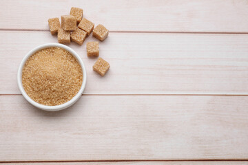 Refined and granulated brown sugar on wooden table, flat lay. Space for text