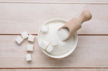 Refined and granulated white sugar on wooden table, flat lay