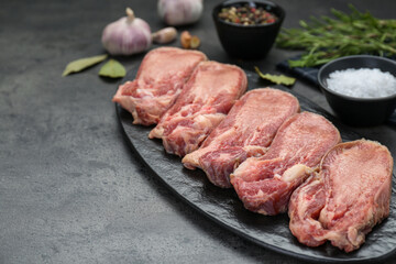 Raw beef tongue pieces on grey table, space for text