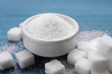 Fototapeta na wymiar Different types of white sugar on light blue wooden table, closeup