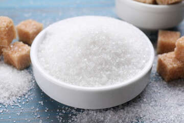 Fototapeta na wymiar Different types of sugar on light blue wooden table, closeup