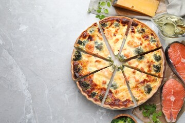 Delicious homemade quiche and ingredients on light gray marble table, flat lay. Space for text