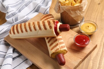 Delicious french hot dog, fries and dip sauces on wooden table