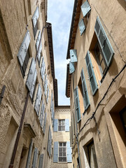 Fototapeta na wymiar Arles, France - 26.04.2023. Street view of Arles, in the south of France. Facade of old residential building with shutters on windows. Charming narrow street view of Arles, Provence south of France.