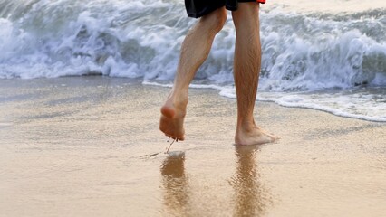 male legs go into the sea closeup