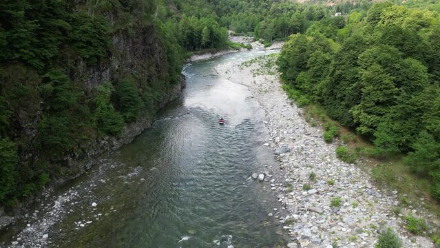 Go rafting on the river with dinghies immersed in the rapids of the stream and the nature of the canyon in Val Sesia Alagna Piedmont Alps mountains - drone view of summer water sport activities 