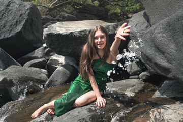 girl splashes water from the stream into the camera