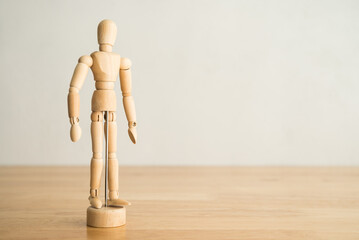 Wooden man figure on wooden table with white wall background copy space. Human resource (HR) in business company, headhunter recruitment, job interview and course training development skill concept.