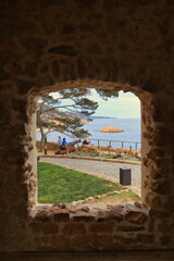 Tossa de Mar, Catalonia, Spain. View of the sea from the castle through an old stone window