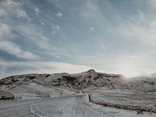 Snowy mountain landscape with cloudy blue sky.