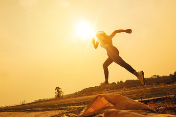 Silhouette of young woman running sprinting on road. Fit runner fitness runner during outdoor workout. Selected focus