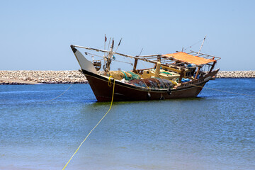 Traditional wooden dhow boat in the port city of Al Ashkhara. Sultanate of Oman - obrazy, fototapety, plakaty
