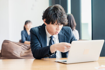 オフィスでパソコンと格闘するビジネスマン