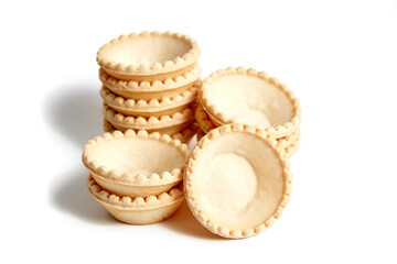 Tartlet shells isolated on white background. Stacked empty mini tart shells for portable desserts