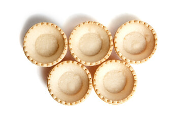 Tartlet shells isolated on white background, top view. Empty mini tart shells for portable desserts