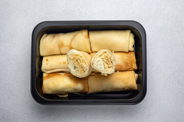 Delicious pancakes in a black box. Delivery