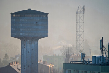 Ostrowiec Świętokrzyski podczas mgły. Widoczny terem starej huty z betonową , wysoką wieżą ciśnień . 