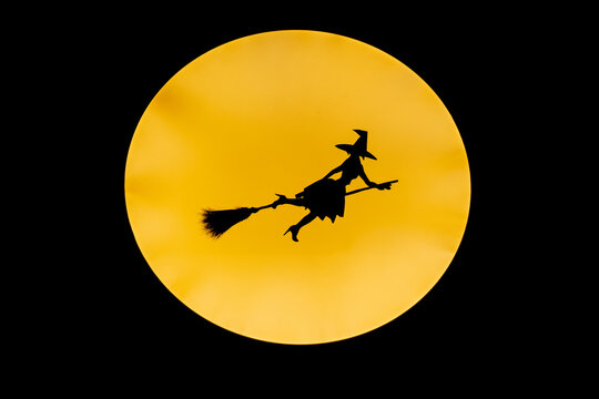 witch flying across the full moon