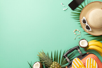 Tropical vacation concept. Top view photo of a suitcase and hat with sunglasses, palm leaves and...