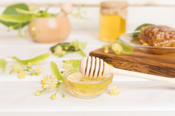 Linden honey with leaves and flowers on table