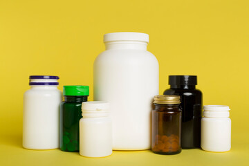 Plastic bottles for vitamins on color background