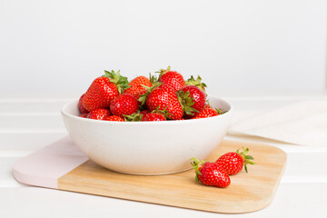 Fresh strawberries in bowl on wooden table