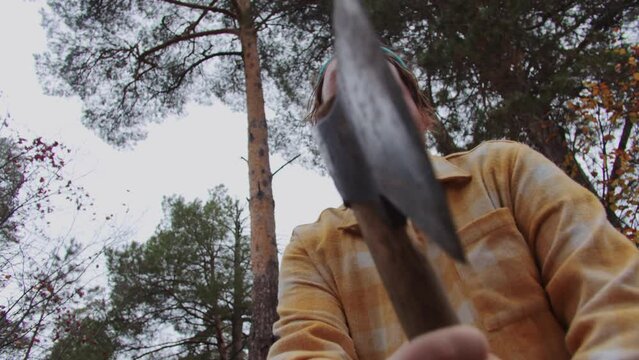 Bearded man swings an axe - bottom-up view