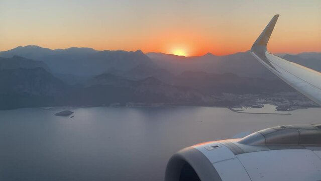 Sunset and mountains view from window of the plane