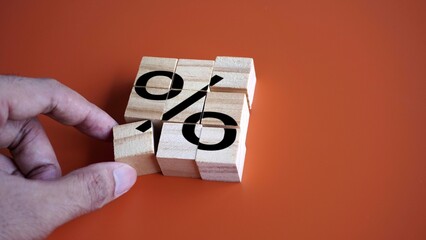 Hand arrange wooden cubes with percentage sign. Debt restructuring, loan refinancing and pay off debts concept