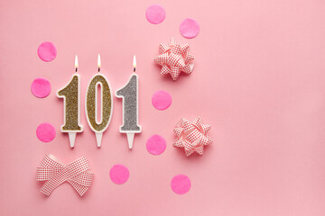 Number 101 on pastel pink background with festive decor. Happy birthday candles. The concept of celebrating a birthday, anniversary, important date, holiday. Copy space. banner