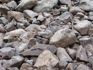 Stones of different sizes and shapes on the ground, shore area of a lake 
