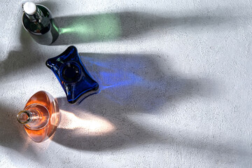 Minimal concept glasses bottles on sunny day. Various colored bottles brightly lit showing reflections and shadows