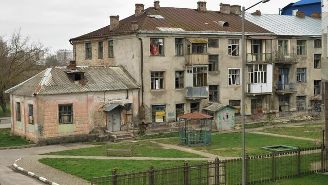 Housing emergency in the city centre. A dilapidated block of flats. Old, dilapidated house, dilapidated state, rickety buildings. Glass in the windows is broken out, the walls are painted over