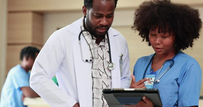 African american doctor teaches medical woman student on tablet computer at hospital. Medicine medical and health care concept. Surgery team operating in a surgical room