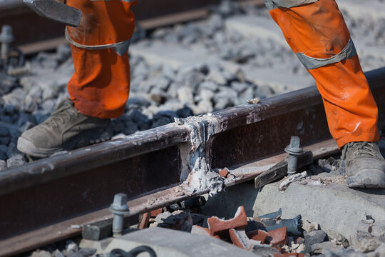 Crop railroad worker during rail reparation process
