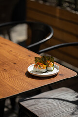 Portion of japanese hand rolls with shrimp and caviar on table