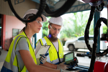 Both of engineers installing and testing a large robotic arm. before sending it to customers for use in the industry