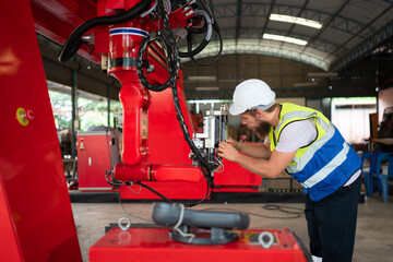 Fototapeta premium An engineers installing and testing a large robotic arm. before sending it to customers for use in the industry