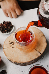 Different types of tea. Black, green and hibiscus sorts on a white table with teapot and glasses.